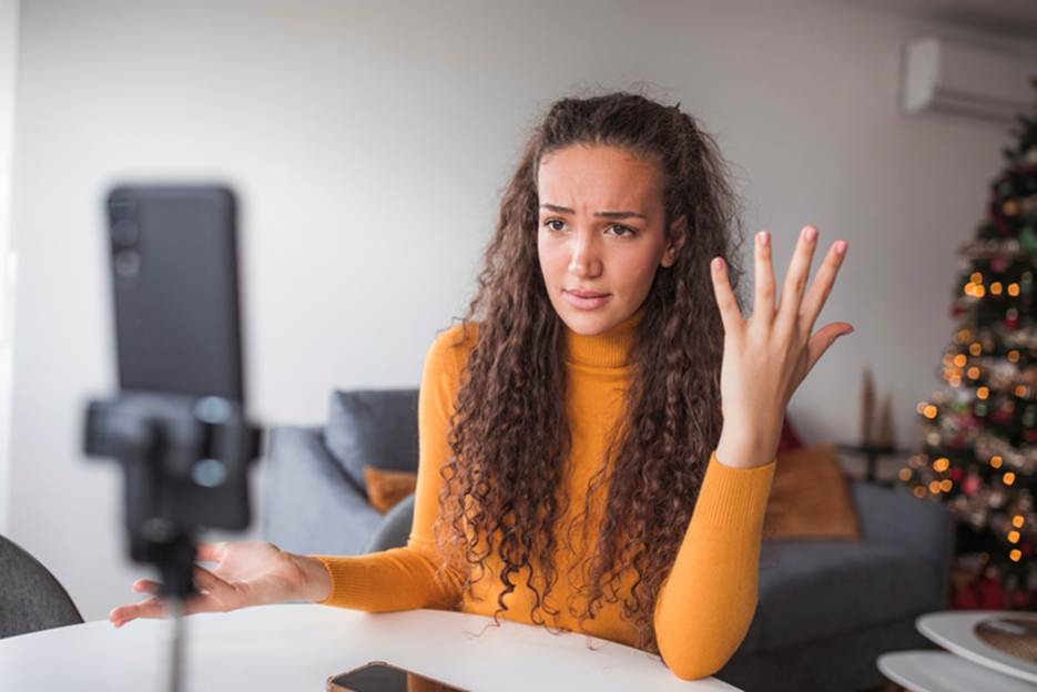 A person with curly hair holding her hand up

AI-generated content may be incorrect.